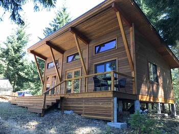 Modern wooden house with a single-slope roof and minimalist facade in the forest