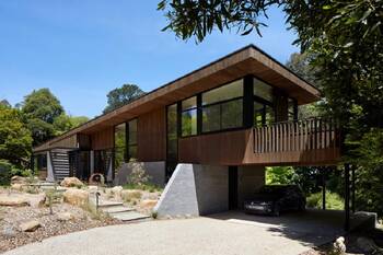 Modern wooden facade with panoramic glazing in a natural setting