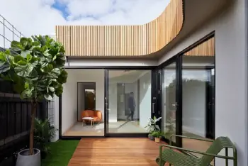 Modern home with wave-shaped wooden facade and panoramic glazing