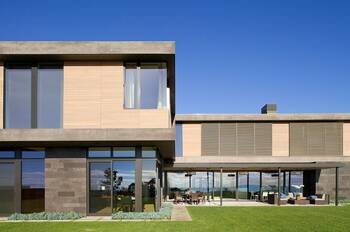 Modern coastal house with minimalist facade: a combination of concrete, wood and glass