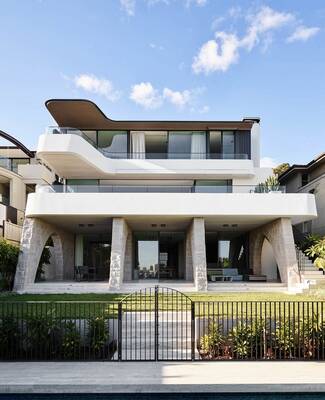 Modern facade with flowing lines: interplay of stone, wood, and white surfaces