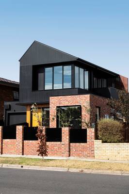 Dual Facade: Modern House with Contrasting Combination of Brick and Black Metal Cladding