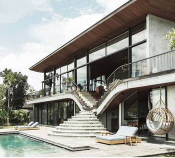 Modern tropical facade with curved staircase and contrasting materials