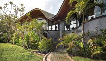 Tropical villa with a wave-shaped facade: harmony of concrete, wood, and glass