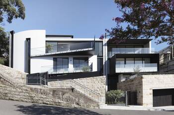 Modern façade with contrasting textures: white minimalism on a stone foundation