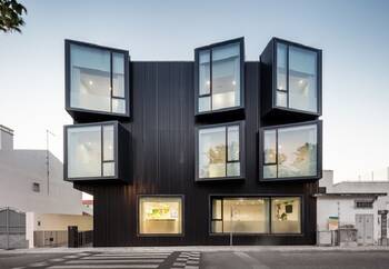 Modular black facade with protruding glass boxes