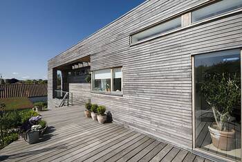 Modern wooden facade with horizontal siding and integrated deck