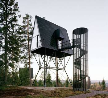 Modern A-frame tower house on stilts in the forest