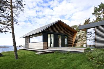 Minimalist Waterfront Cottage with Contrasting Wood and Glass Facade