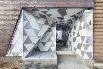 Geometric Facade with Triangular Texture: A Modern Portal in a Brick Building