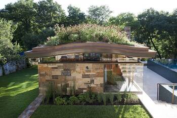Modern pavilion with stone facade and green roof