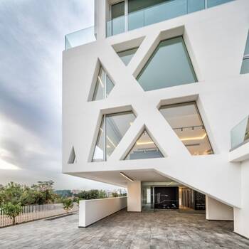 Geometric white facade with X-pattern window openings