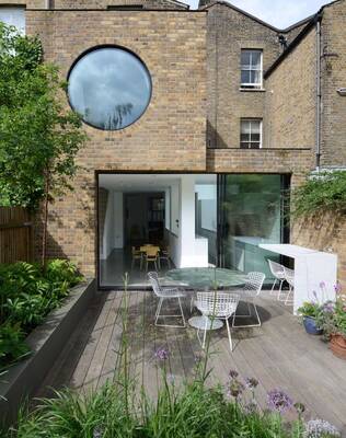 Modern Brick Facade Reconstruction with Circular Window and Panoramic Glazing