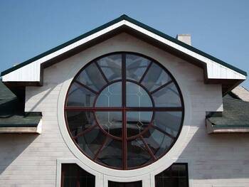 Elegant facade with a rosette round window and contrasting green trim