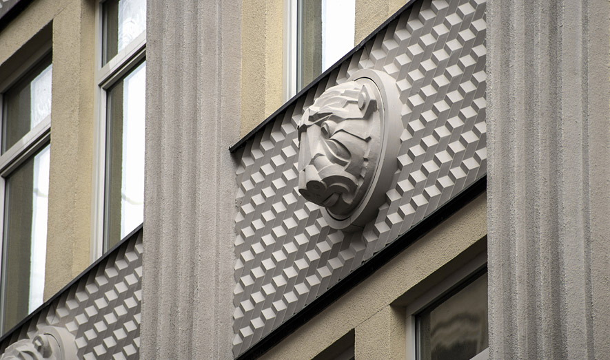 The lion mascaron on the fiberglass facade