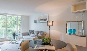 Bright modern living room with panoramic windows and turquoise accents