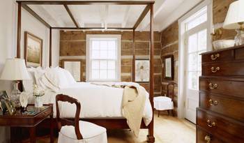 Refined Rustic Elegance: Bedroom with Log Walls and a Classic Four-Poster Bed