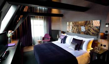 Elegant attic interior with contrasting beams and luxurious purple palette