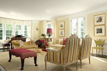 Bright classical living room with raspberry accents and panoramic windows