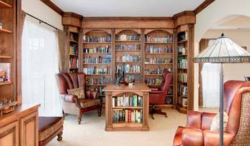 Photo of library in cottage in artistic style.