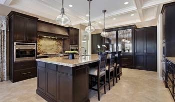 Luxurious Dark-Toned Kitchen with Contrasting Marble Countertop and Coffered Ceiling
