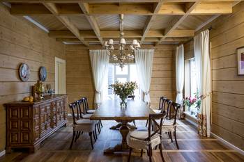Cozy dining room in a wooden house: harmony of rustic style and classic elements