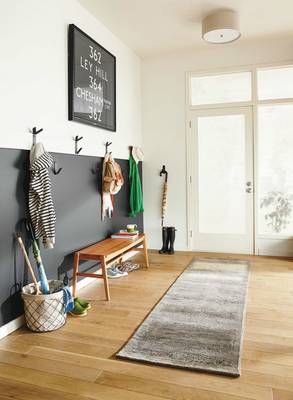 Minimalist entryway with contrasting gray panel and functional space organization