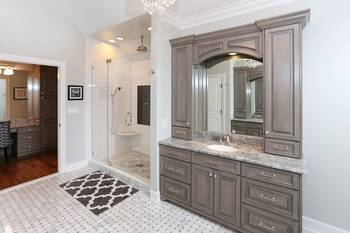 Elegant bathroom in taupe tones with classic cabinetry and glass shower enclosure