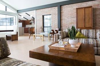 Contemporary open-space interior with brick accent wall and wooden elements