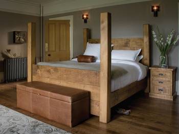 Rustic Bedroom with Massive Wooden Four-Poster Bed: Naturalness and Character in Country House Interior