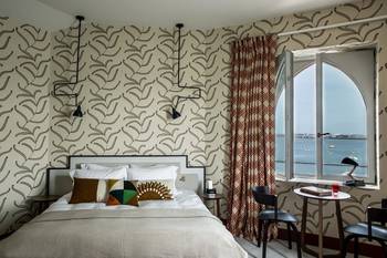 Coastal Chic: Hotel Room with Panoramic Arched Window and Graphic Wallpaper