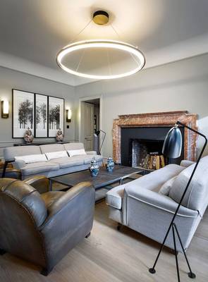 Modern living room with classic marble fireplace facade and ring chandelier