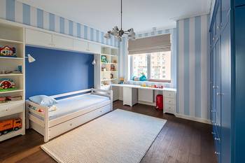 Functional children's room in blue and white palette with vertical stripes and smart storage solutions