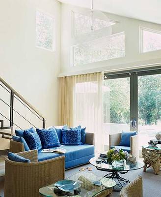Modern Living Room with High Ceilings: Blue Accents in a Light-Filled Space