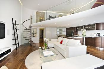 Two-level open-plan loft: elegance of spiral staircase and contrasting finishes