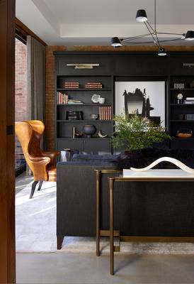 Industrial Elegance: Dark Built-in Shelving and Brick Wall in a Contemporary Country House Interior