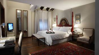 Sophisticated Ethnic-Inspired Bedroom with Red Accents and Wooden Beams