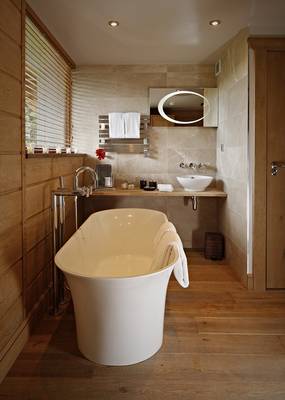 Elegant spa bathroom in natural tones with freestanding tub
