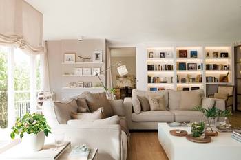 Light-filled living room with illuminated bookshelves: a balance of comfort and functionality