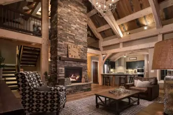 Modern chalet: double-height space with stone fireplace and wooden beams